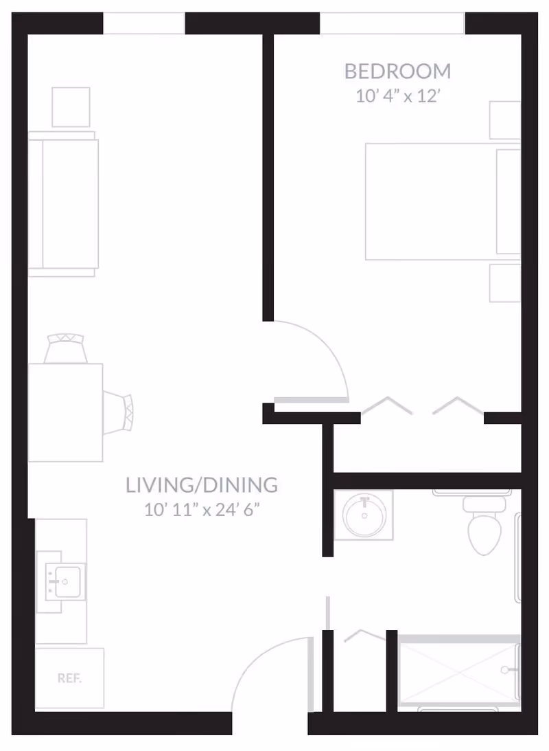 Floor plan of a one-bedroom apartment at Inspired Living Ocoee, showing a bedroom measuring 10 feet 4 inches by 12 feet, a combined living and dining area measuring 10 feet 11 inches by 24 feet 6 inches, a kitchen area with a refrigerator and sink, and a bathroom with a sink, toilet, and shower.