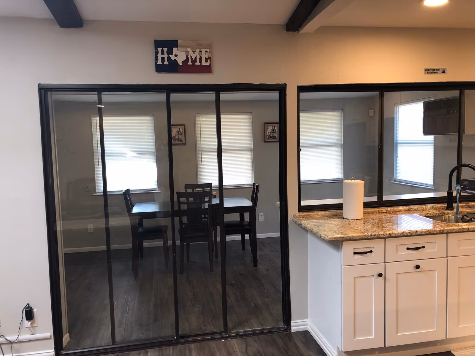 Interior view showing kitchen counter and sink with a sliding glass door to a dining room.
