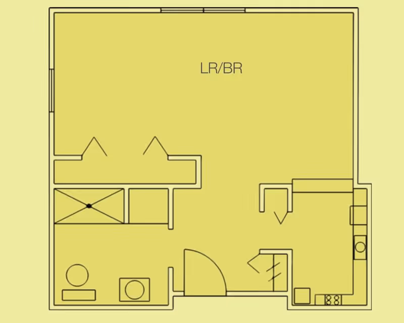 Architectural floor plan of a senior living unit showing a combined living room/bedroom area, a bathroom with a shower, toilet, and sink, and a kitchen area with appliances and counters.