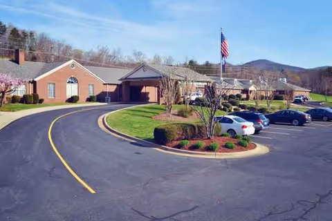 Exterior view of The Landmark Center facility with a curved driveway and flagpole.