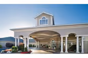 Front exterior view of Life Care Center of Coeur d'Alene showing a covered entrance with white columns under a clear blue sky.