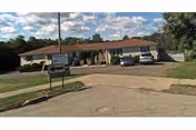 Front view of Rebecca's Personal Care Home Inc., a single-story building with sign and parked cars.