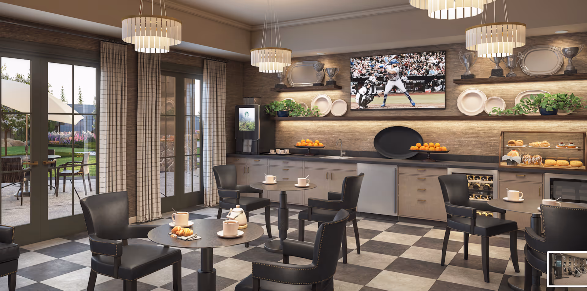 A cozy dining area with round tables and black chairs, each table set with cups and a teapot. The room features checkered flooring, large windows with curtains, and a counter with fruit, pastries, a coffee machine, and a wine cooler. A TV on the wall displays a baseball game, and shelves hold trophies, plates, and plants. Outside, there is a patio with tables, chairs, and umbrellas.