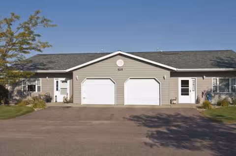 Front view of Tea Retirement Living building with two white garage doors.