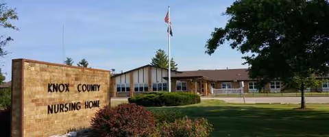 Front exterior of Knox County Nursing Home with a sign and flagpole.