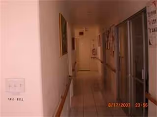 Long indoor corridor in a senior facility with doors along the walls.