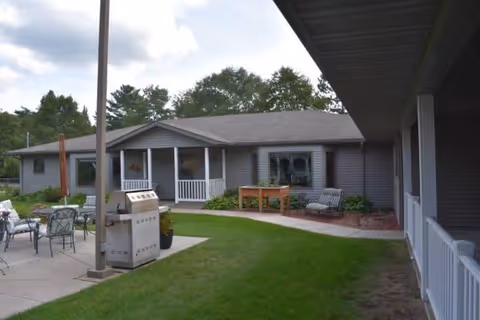 Single-story Harmony House of Motley exterior with patio seating and manicured lawn.