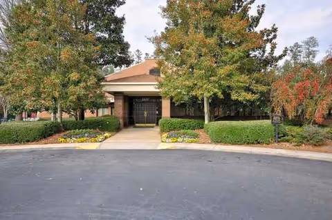 The Montclair front entrance of a senior living facility with trees and landscaping.