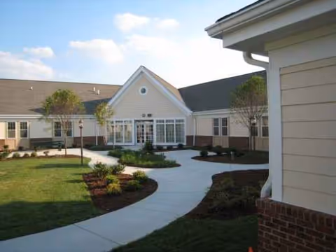 Exterior view of Huntersville Oaks front entrance with curved walkway and landscaped grounds.