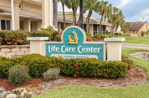 Front view of Life Care Center of Punta Gorda sign with landscaped entrance.