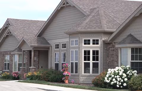 Front exterior of Vista Pointe II senior living facility with windows and landscaped shrubs