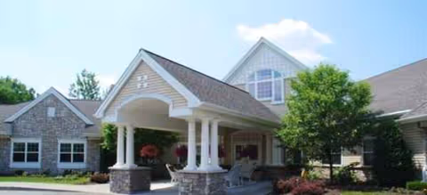 Exterior view of Brookdale Pittsford facility with a covered entrance and landscaped front yard.