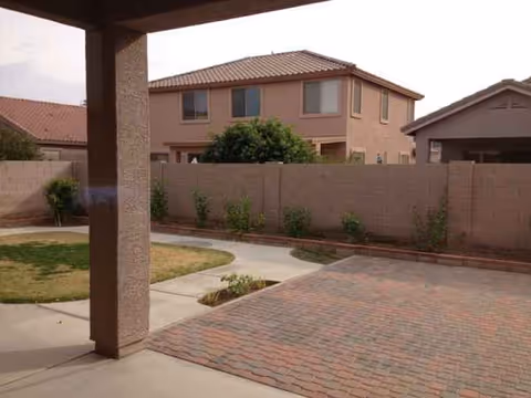 Outdoor courtyard of a senior living facility with brick-paved walkway and beige buildings
