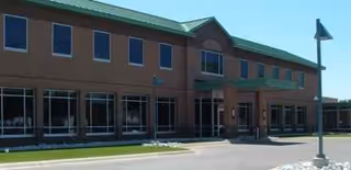 Exterior view of a brick senior care facility with entrance canopy.