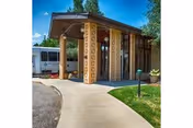 Front entrance of a senior living facility with decorative lattice columns and curved sidewalk.