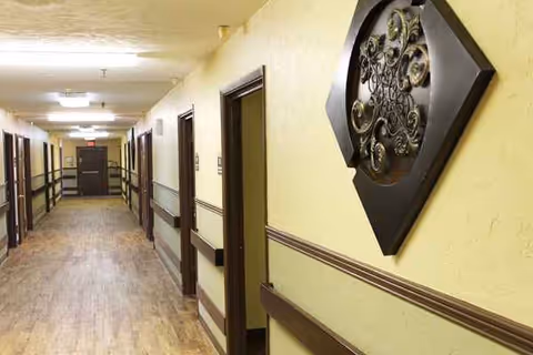 Long corridor in a senior living facility with multiple doors along the hall.