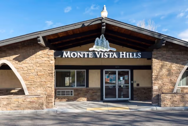 Front entrance of Monte Vista Hills Health Care Center showing the building facade, peaked roof, and glass double doors.
