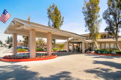 Exterior view of Mirada Hills Rehabilitation and Convalescent Hospital entrance with covered drop-off, drive, and landscaping.