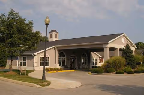 A single-story senior living facility with a covered entrance and manicured landscaping.