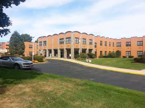 Exterior view of St. James Rehabilitation & Healthcare Center with driveway and lawn.