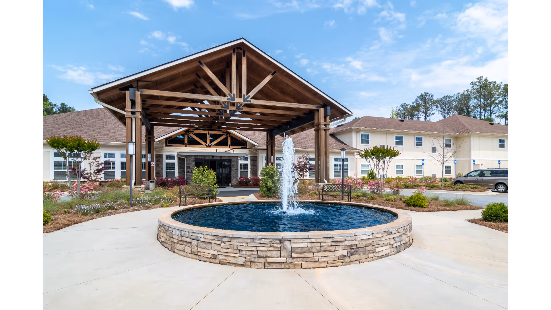 Front view of Prema at Ashton Hills with a fountain, stone wall, and wooden entrance canopy.