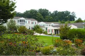 Exterior view of Glen Meadows Retirement Community with connected white buildings and green lawn.