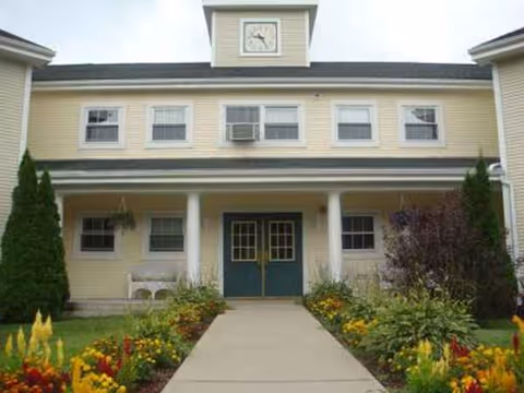 Exterior view of Holy Cross Senior Housing entrance with colorful garden landscaping.