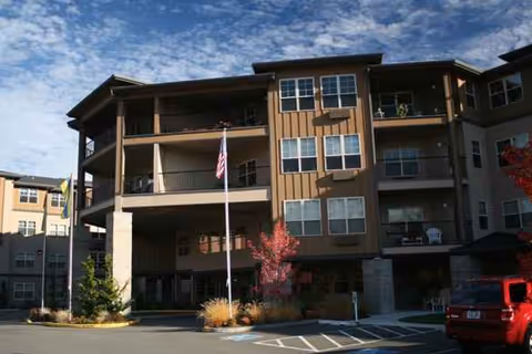 Exterior view of North Creek by Bonaventure building with parked cars and flagpole.