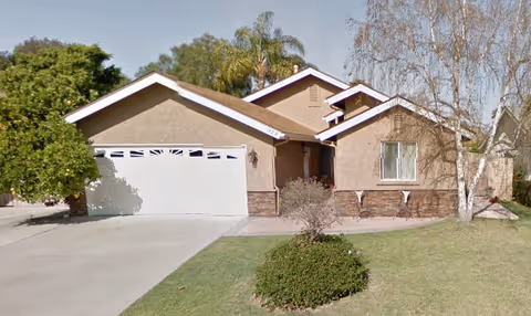 Front exterior view of a single-story residential care home with a two-car garage.