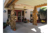 Exterior entrance of Oakleaf Personal Care Homes decorated with cornstalks and pumpkins.