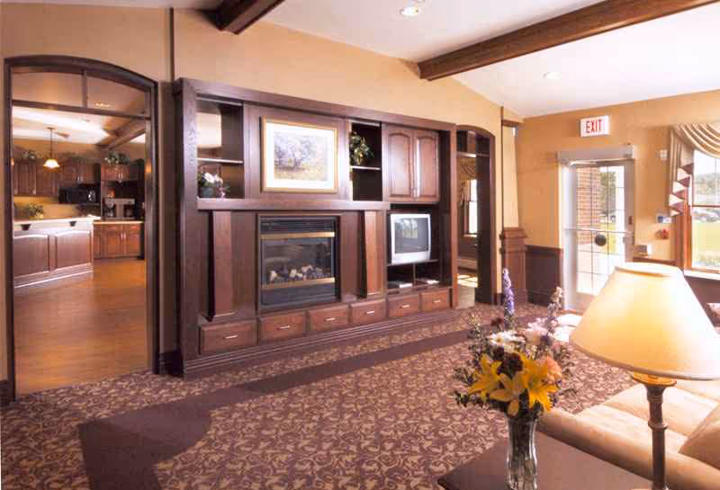 Rennes Health and Rehab Center lobby with wood cabinetry, fireplace, TV, and seating.