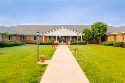 Front view of Clinton House Rehabilitation and Healthcare Center with a central walkway and green lawn.