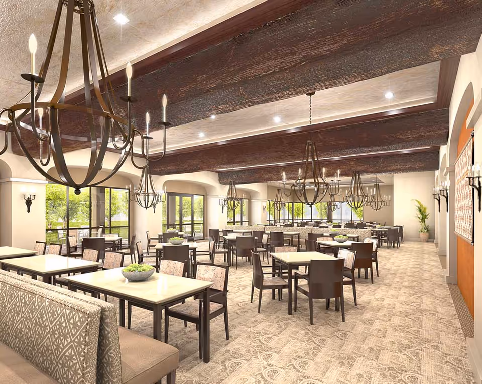 Spacious dining room with multiple tables and chairs, ornate chandeliers, and large windows letting in natural light.