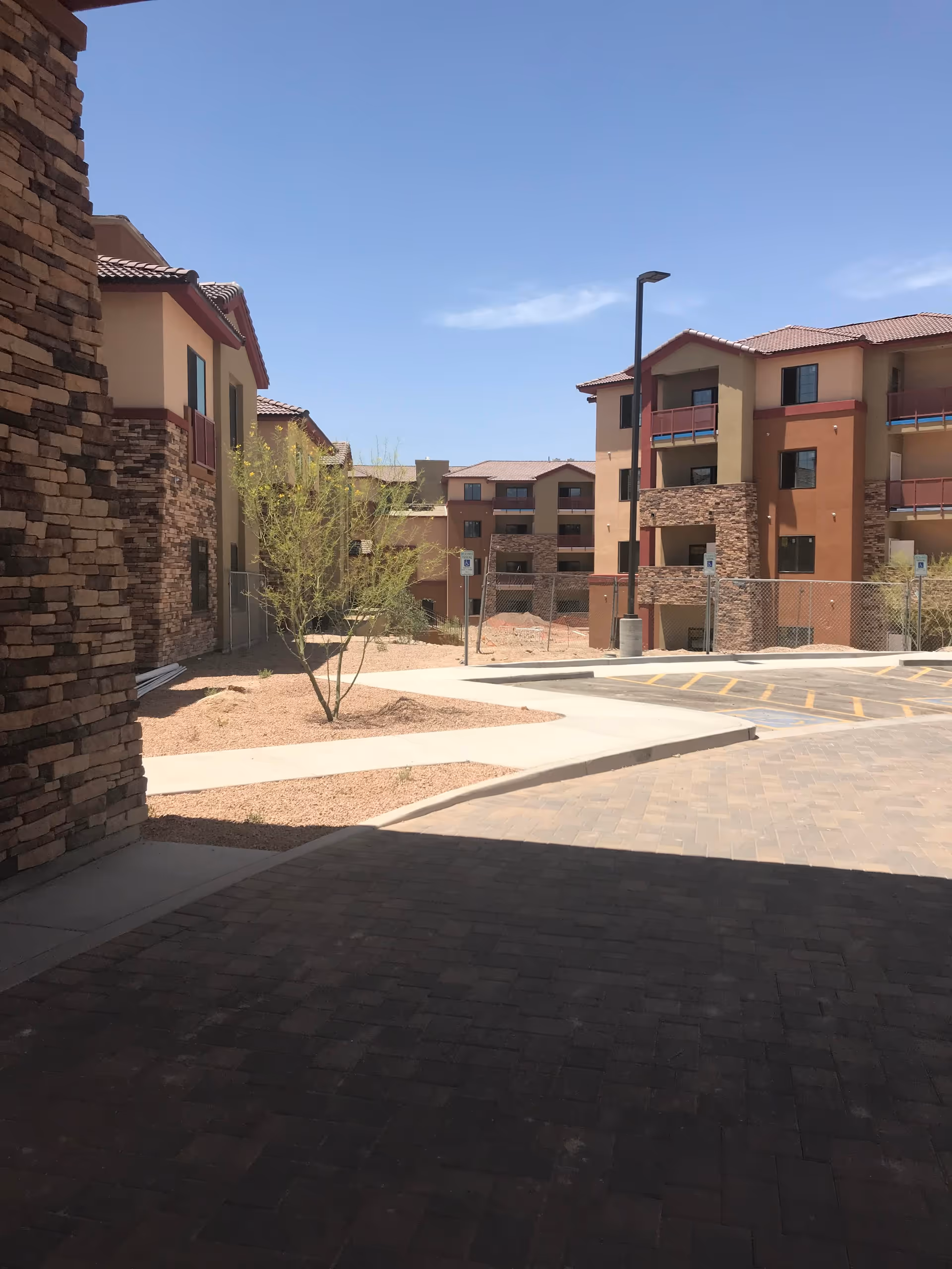 A view of the exterior of Canyon Winds Assisted Living & Memory Care, featuring buildings with stone accents and surrounding landscaping.