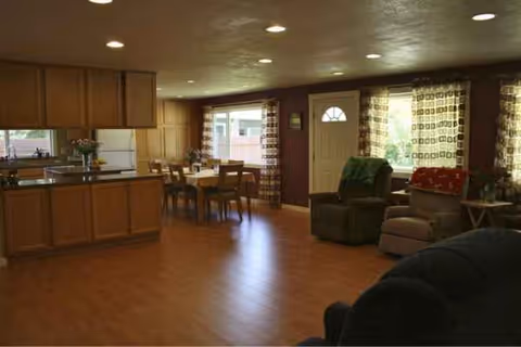 Spacious interior common area with kitchen, dining table, and multiple seating chairs.