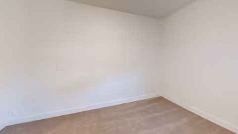 Empty room with beige carpet, white walls, and a white ceiling. The room has no furniture or decorations.