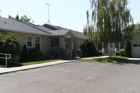 Cenoma House senior living facility front exterior with entrance and landscaping.