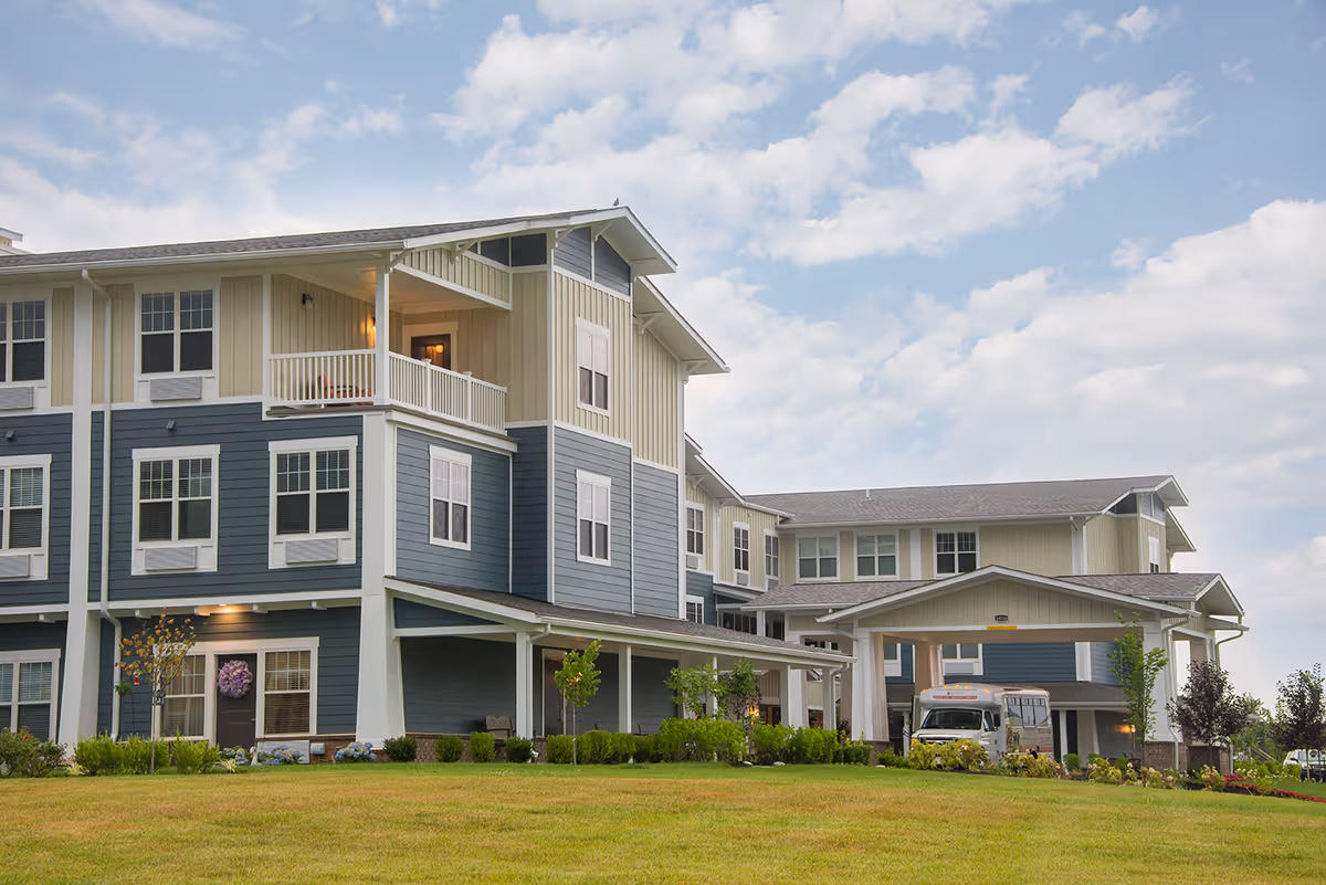 Two-story senior living building with blue siding and a covered entrance.