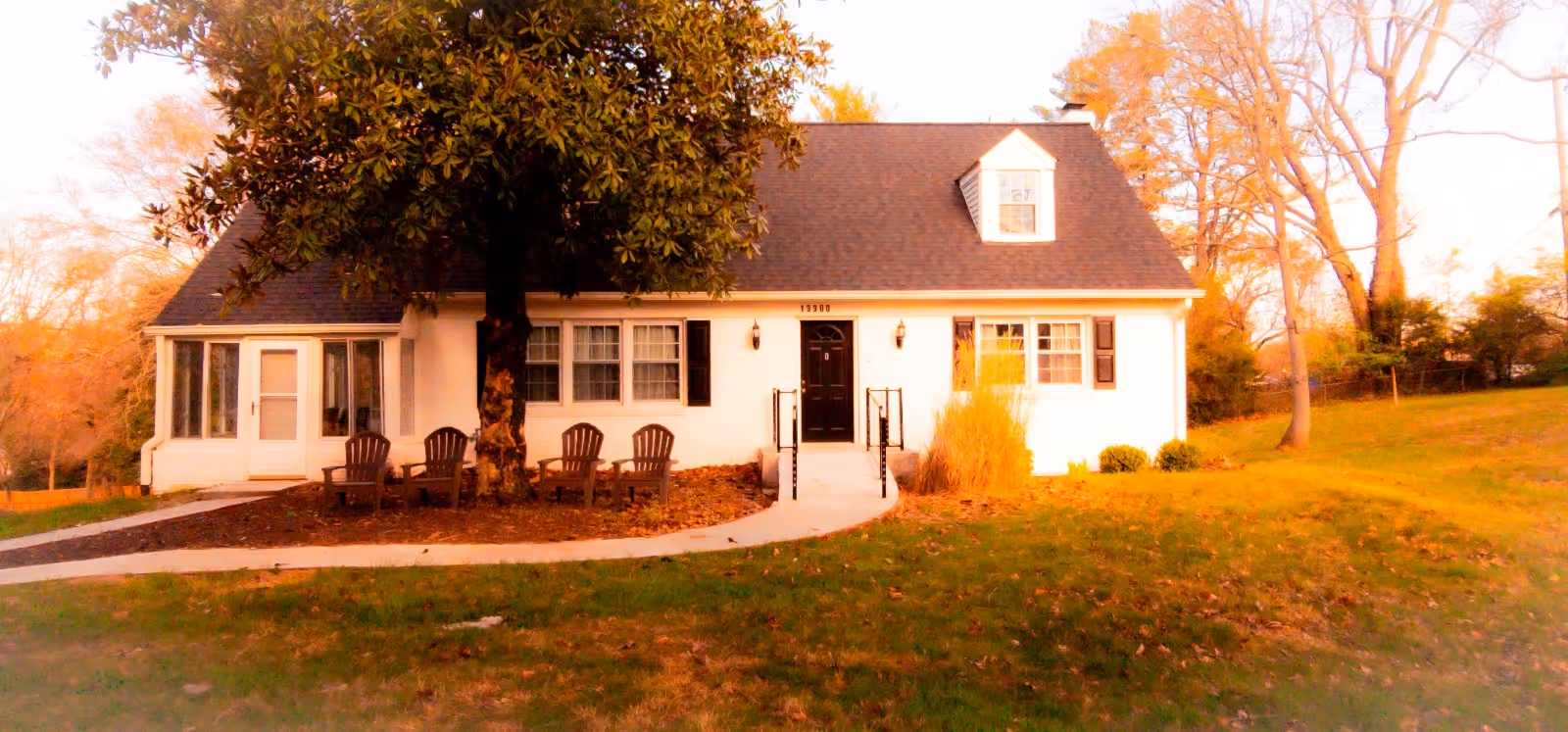 Blossom Haven front exterior: a white cottage-style building with chairs outside.