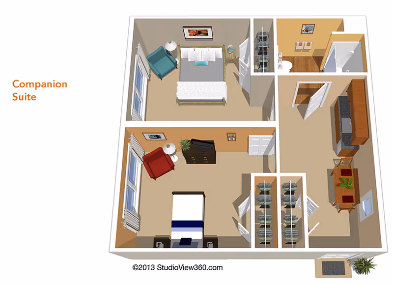 3D floor plan of a companion suite featuring two bedrooms, each with a bed, chair, and nightstand. The suite includes a shared bathroom with a shower, a kitchen area with cabinets and appliances, and a dining table with chairs. Closets are located near the bedrooms. The layout is labeled 'Companion Suite'.