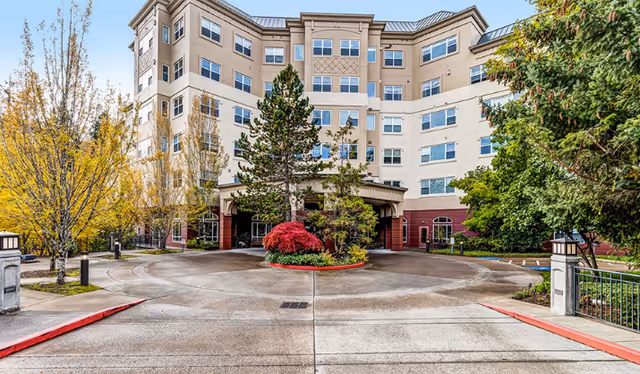 Front exterior of Miramont Pointe, a multi-story senior living building with circular driveway.
