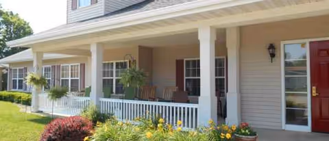 Front view of Shelbyville Manor exterior with a covered porch and well-tended garden.