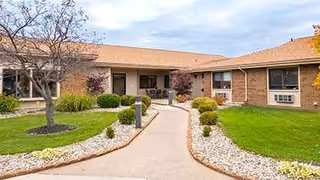 Front view of Edgewood Manor Rehabilitation and Healthcare Center with a curved walkway and landscaping.