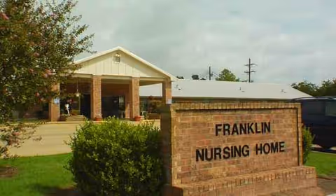 Front view of Franklin Nursing Home with brick sign and building entrance