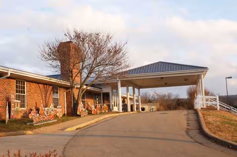 Exterior view of Georgian Gardens Care Center entrance with brick building and covered drop-off.