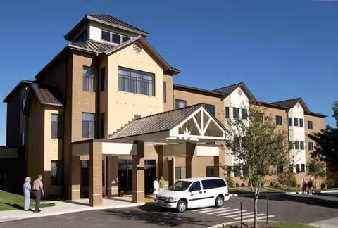 Exterior view of Blue Skies of Texas East building with entrance, parked van, and pedestrians.