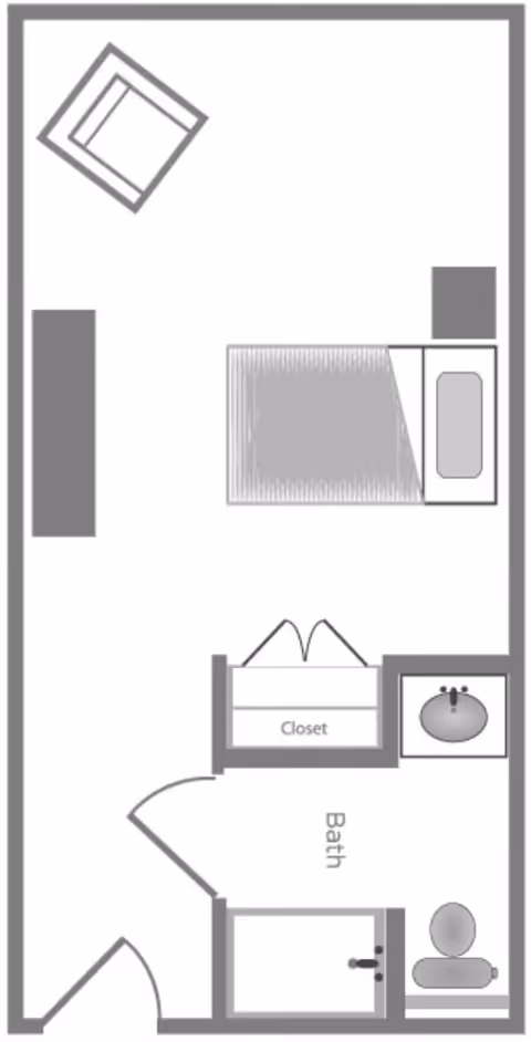 Floor plan of a small living space featuring a bedroom area with a bed, a chair, a closet, and an attached bathroom with a sink, toilet, and shower.