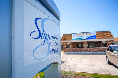 Exterior view of Signature HealthCARE of Muncie with a large sign and a parked car.