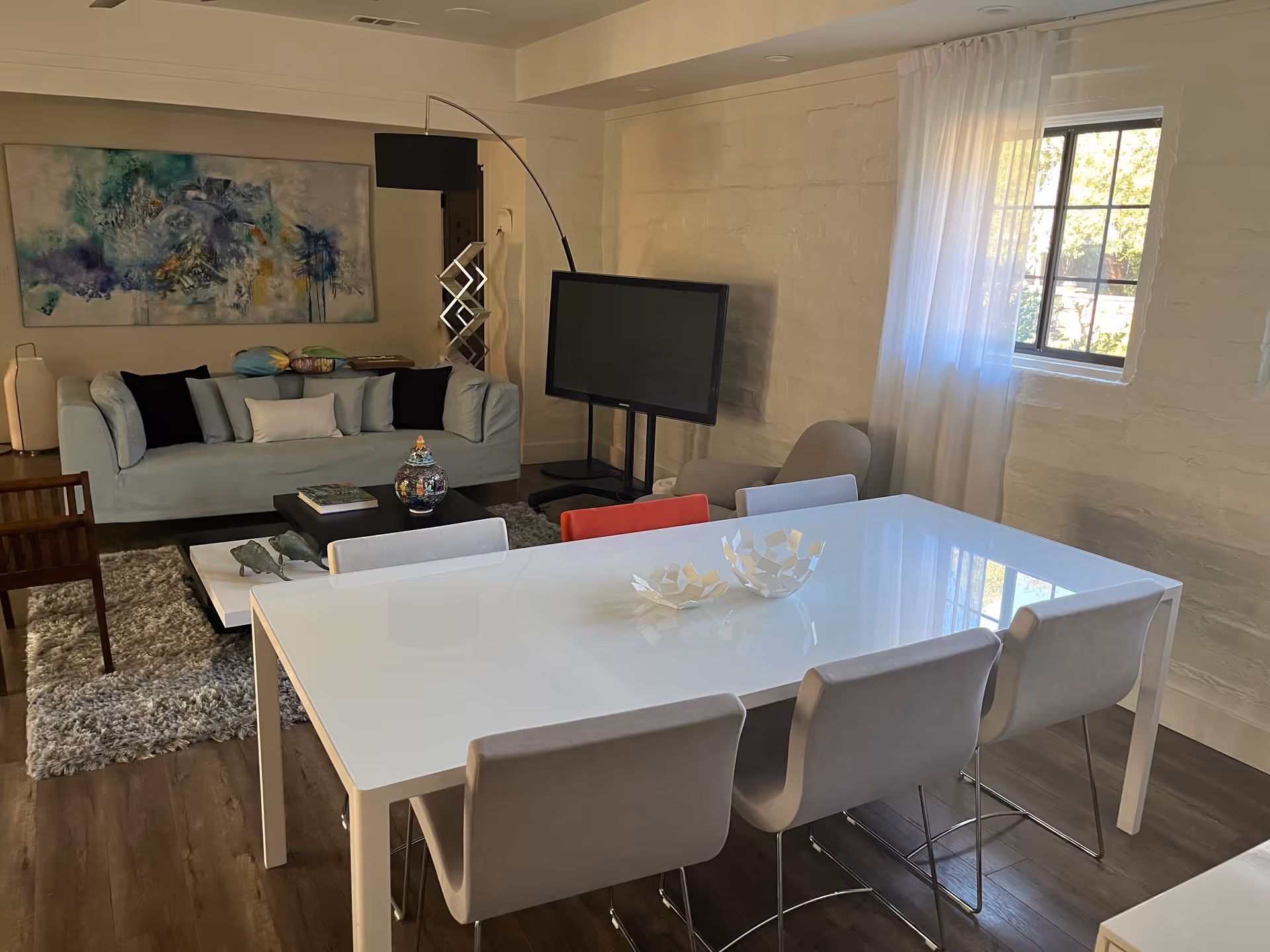 A modern living area with a sofa, dining table, and TV.