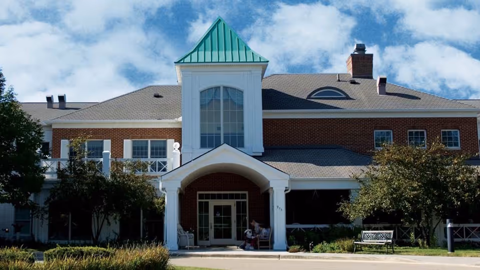 Exterior view of River Glen of St. Charles senior living building with arch entry